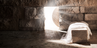 The rock has been moved from Jesus's burial site, and a white cloth is left on the stone.