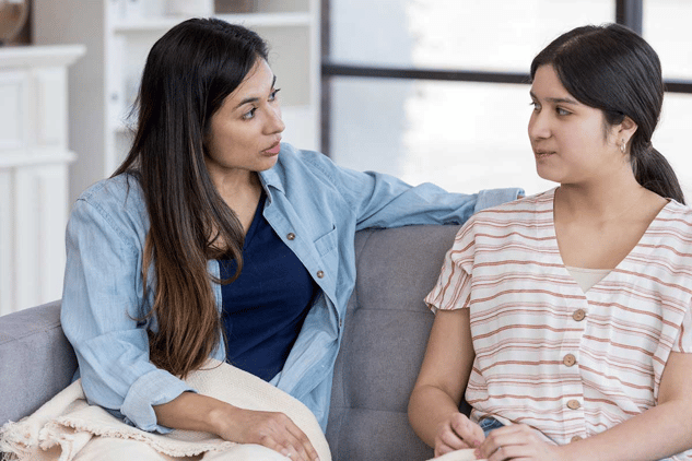 mom talking with daughter on couch